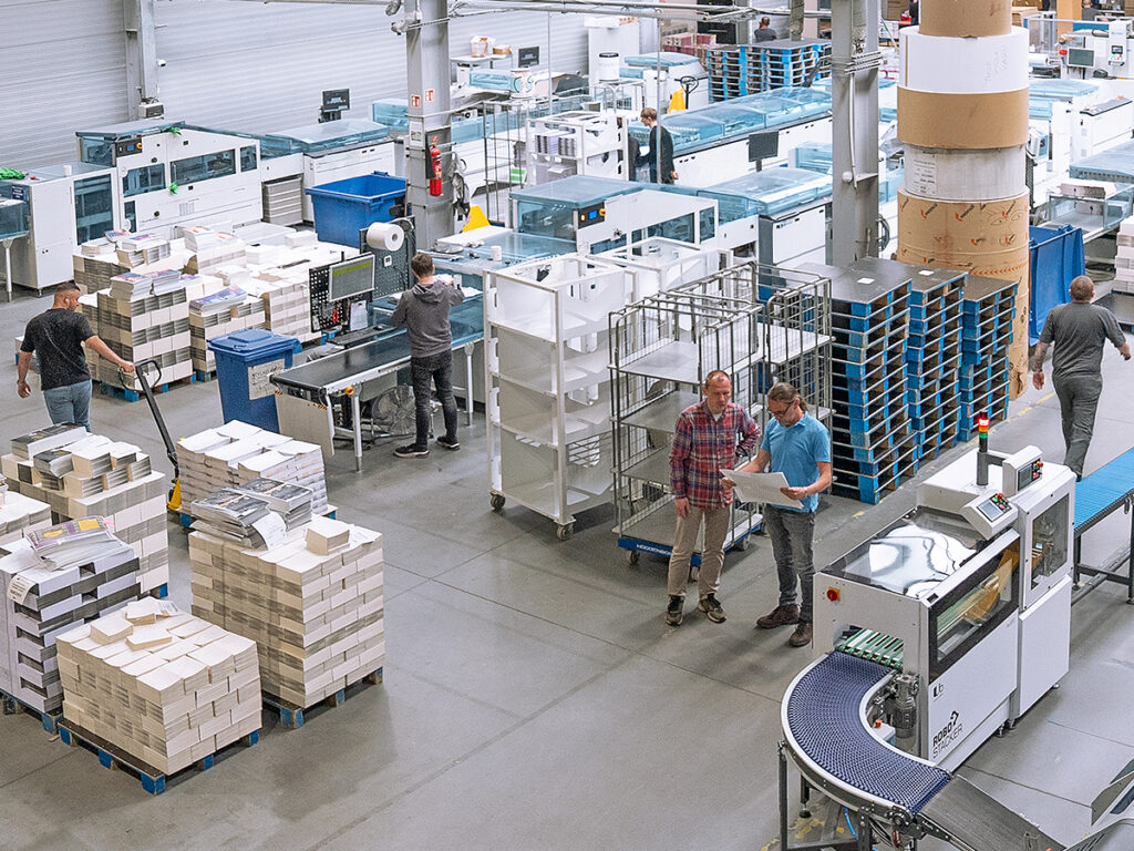 Zdjęcie pokazuje halę produkcyjną w drukarni książek.
