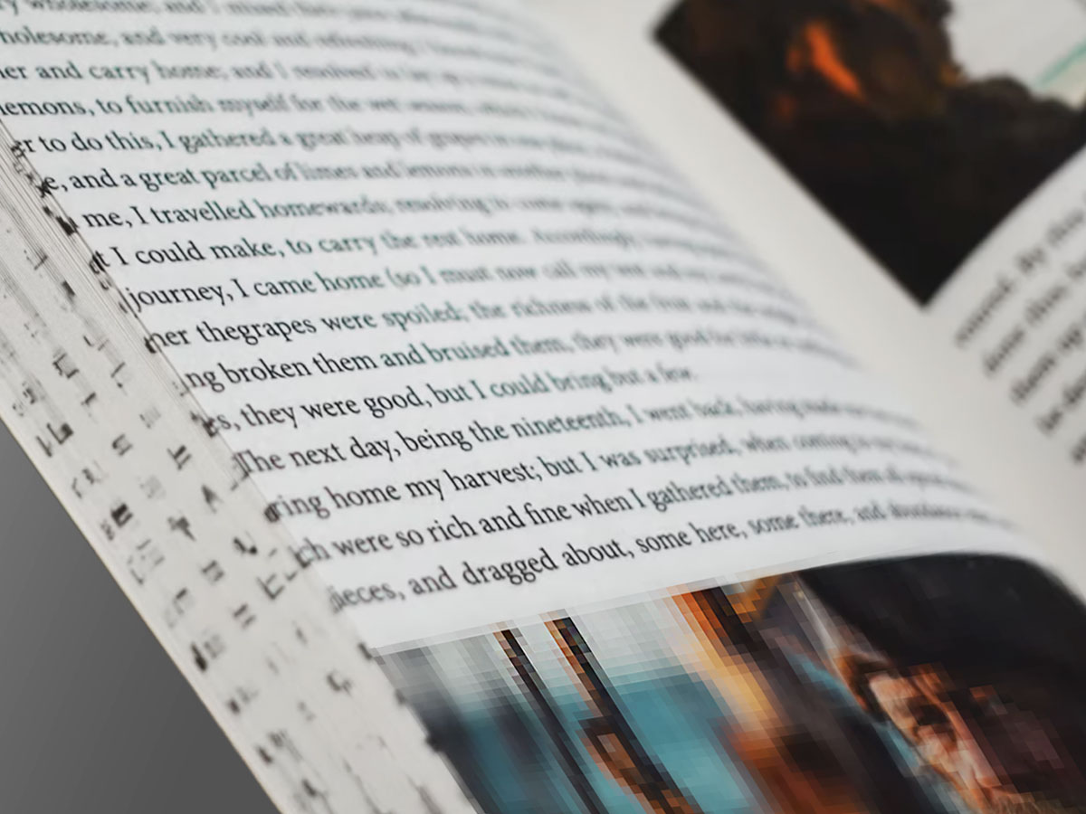 Zbliżenie na otwartą książkę z tekstem i fotografiami – przykład publikacji źle przygotowanej do druku.