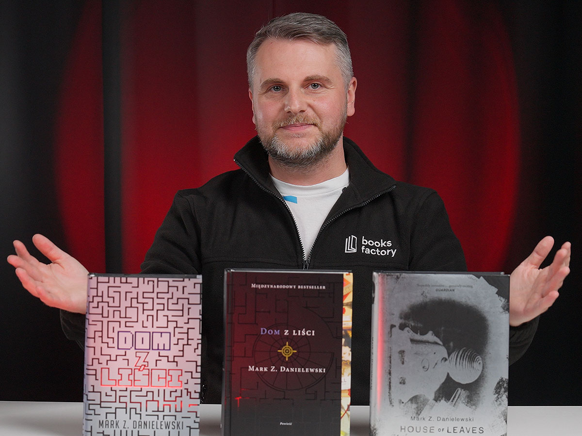Prowadzący Book Anatomy w czarnej bluzie Books Factory przy trzech wydaniach „Domu z liści”: MAG, Znak i Doubleday